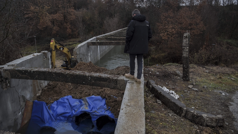 A security officer walks on a site damaged by an explosion in the village of Varage near the town of Zubin Potok