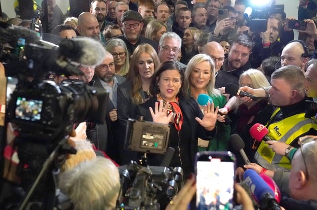 Sinn Féin leader Mary Lou McDonald gestures with her hands alongside deputy Michelle O'Neill (centre right) as they are surrounded by media at the RDS in Dublin