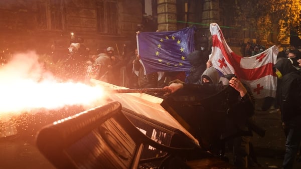 Protesters holding Georgian and European flags clash with police during a demonstration