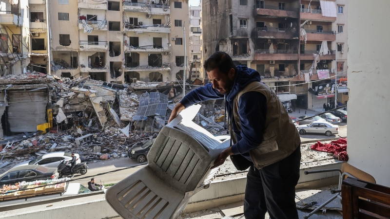 A staff member of the Amel Association, a Lebanese non-governmental organisation, gathers items at their branch that was damaged in an Israeli strike