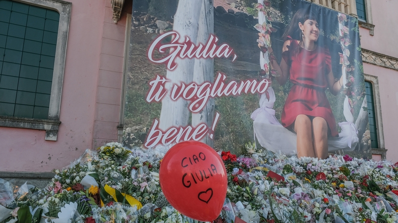 Floral tributes laid at the foot of a banner bearing a photograph of Giulia Cecchettin who was murdered by her ex-boyfriend