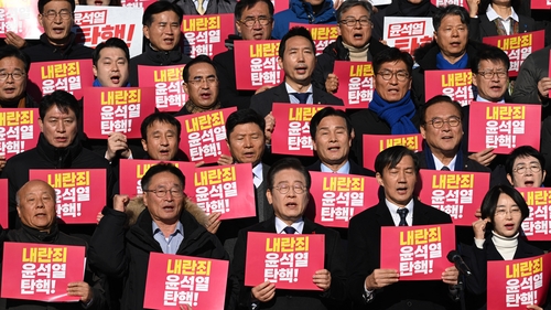 South Korean opposition politicians and civil society activists hold placards reading "Impeach Yoon Suk Yeol for rebellion!"