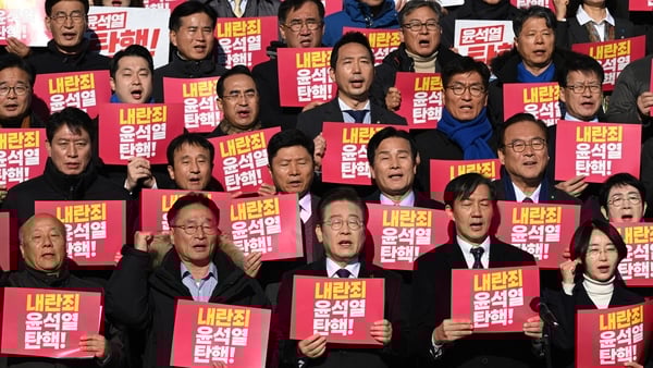 South Korean opposition politicians and civil society activists hold placards reading "Impeach Yoon Suk Yeol for rebellion!"