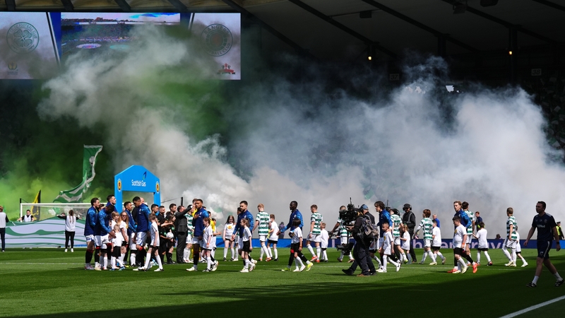 Players and mascots walking on the pitch amid flare smoke ahead of the Scottish Cup final at Hampden Park in May
