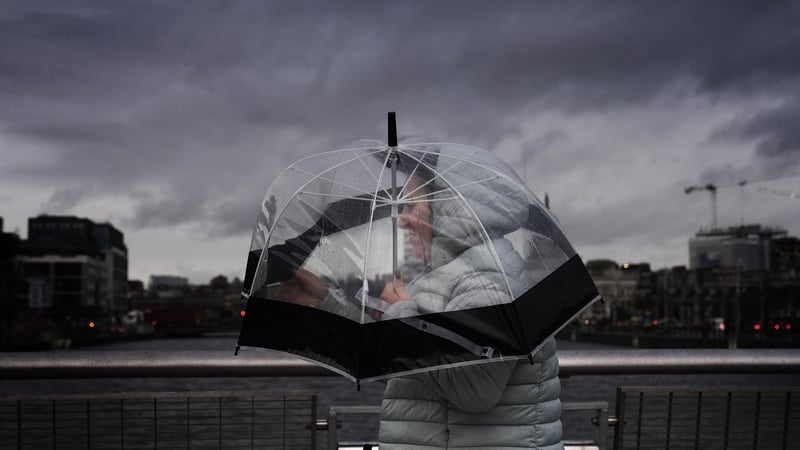 A person takes shelter under an umbrella in Dublin during Storm Darragh in December 2024. Photo: PA