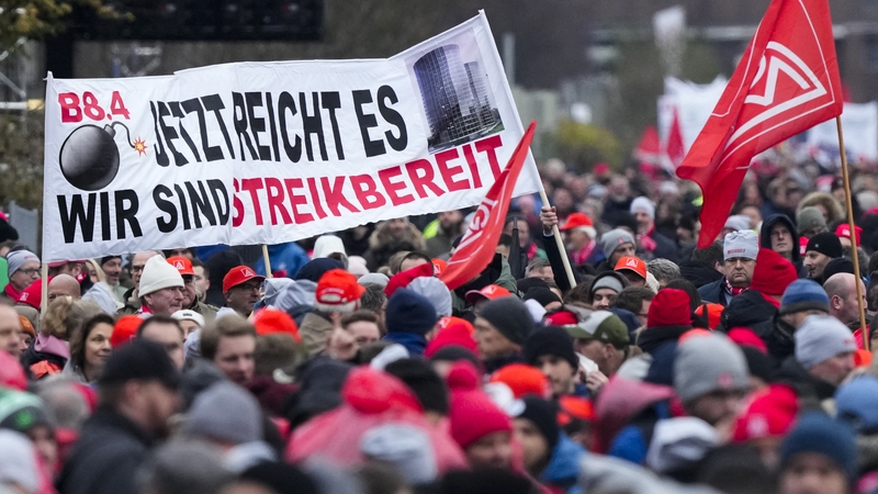 Employees of VW hold up a banner reading 'It's enough - We are ready for strike' as they attend a rally of the IG Metall union in Wolfsburg