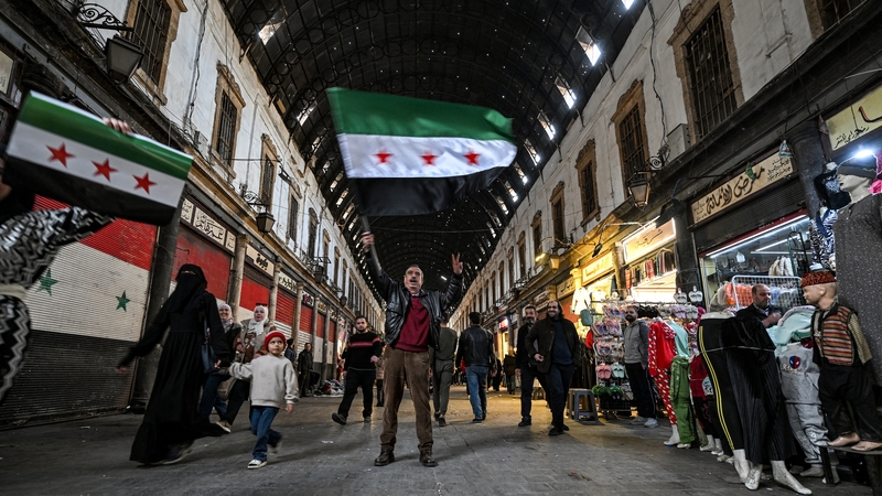 A man waves a flag of the Syrian opposition on a street in Damascus