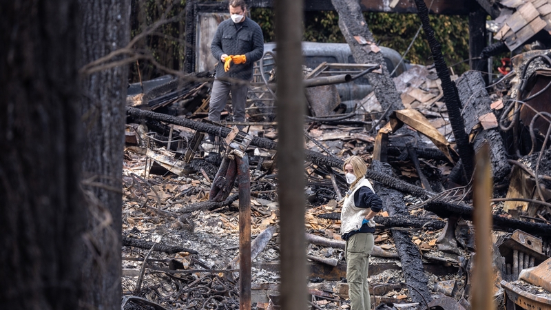 Residents look over the devastation of a home burned on Mariposa de Oro on the first night of the Frankiln fire in Malibu