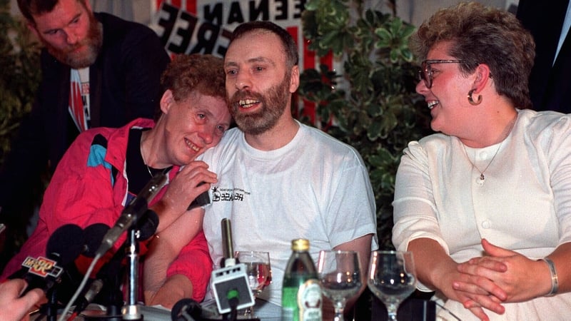 Brian Keenan speaking at a news conference after arriving at Dublin Airport, with his sisters Elain Spence (L) and Brenda Gillham in 1990