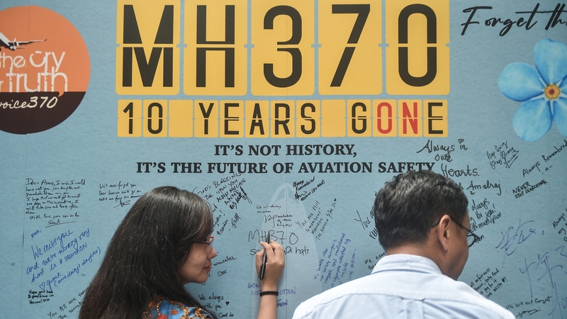 A woman writes a message during an event held by relatives of the passengers and supporters to mark the 10th year since MH370 disappeared