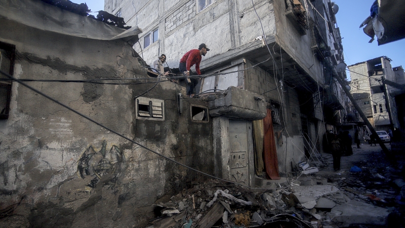A Palestinian man inspects the damage on a rooftop of a house in Nuseirat refugee camp in central Gaza on 16 December