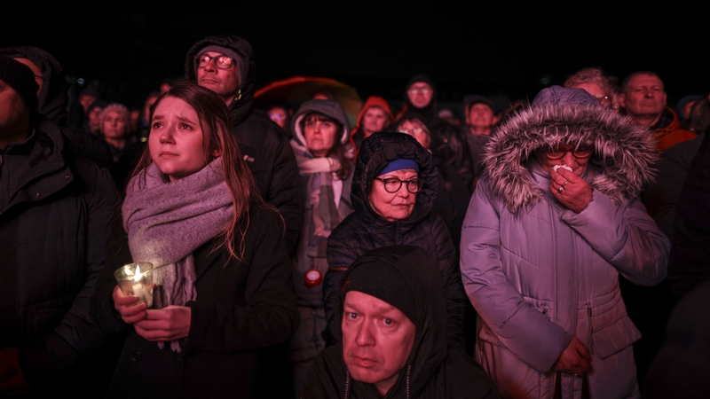 People watch a prayer ceremony on large screens outside the Magdeburg Dom church, the day after a terror attack that has left five people dead in a Christmas market