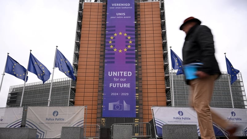 People walk past the European Commission headquarters building in Brussels, Belgium
