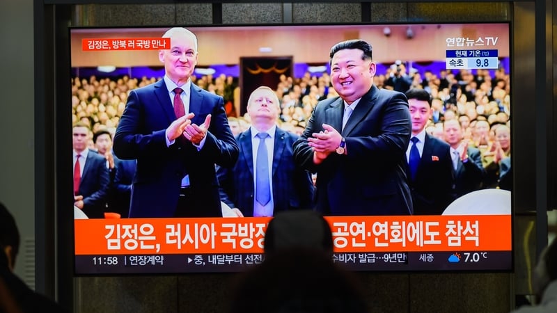 TV broadcast showing news programme with North Korean leader Kim Jong Un (R) with Russia's Minister of Defence Andrei Belousov