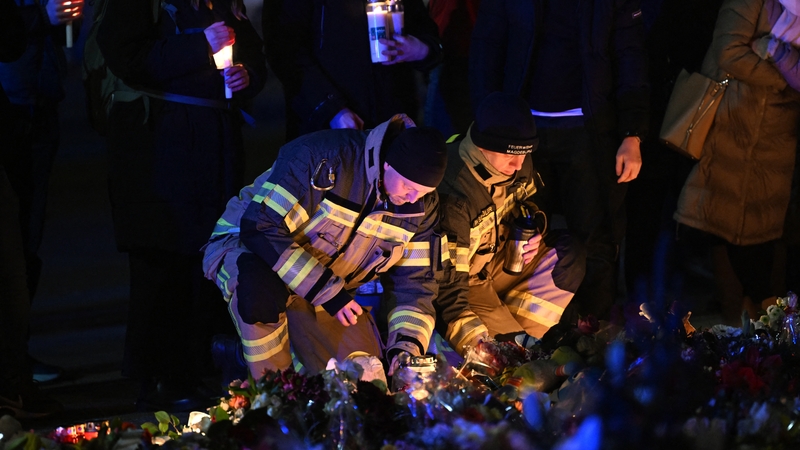 Rescuers light candles at a makeshift memorial outside the market where the attack took place