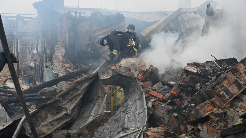 Emergency service workers put out a fire at a house caused by the Russian drone strike in Kharkiv