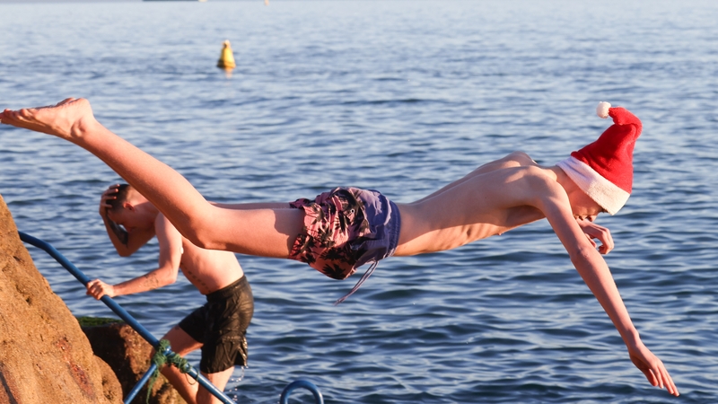 A man in a Santa hat dives into the water at the Forty Foot in Dublin this morning (Image: RollingNews.ie)