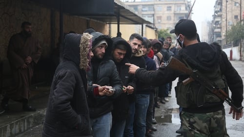 Ousted Assad regime soldiers line up in front of a reconciliation centre opened by the interim administration in Jamiliyeh, Syria