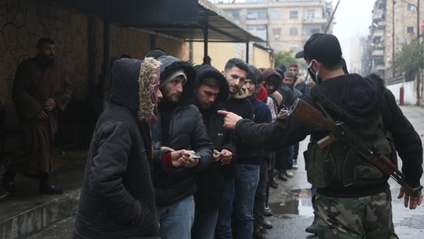 Ousted Assad regime soldiers line up in front of a reconciliation centre opened by the interim administration in Jamiliyeh, Syria