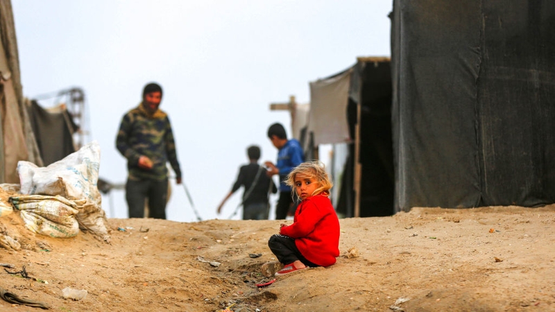 A Palestinian child is seen among makeshift tents during daily life as Israeli attacks continue in Deir al-Balah, Gaza