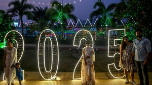 People pose for photos along the promenade in Mumbai, India