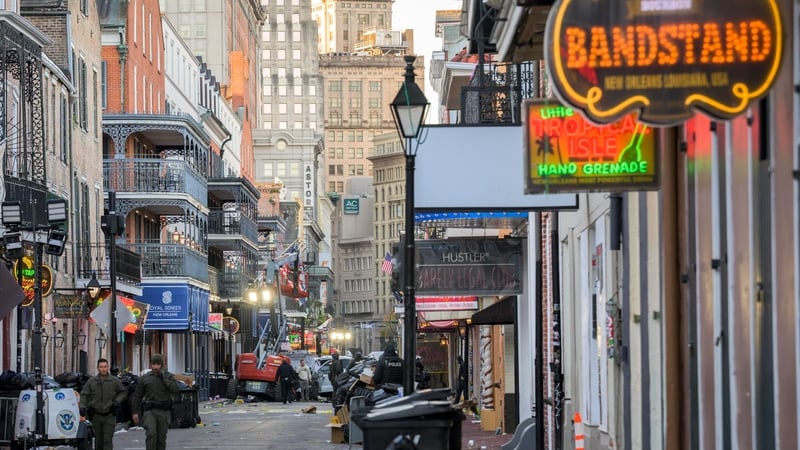 Police investigators surround a white truck that crashed into a work lift in the French Quarter