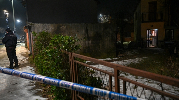 A police officer secures a crime scene after a gunman killed several people in the village of Bajice near Cetinje