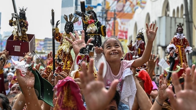 A child reacts during a procession as part of the blessing of Black Nazarene replicas outside Quiapo Church in Manila, Philippines