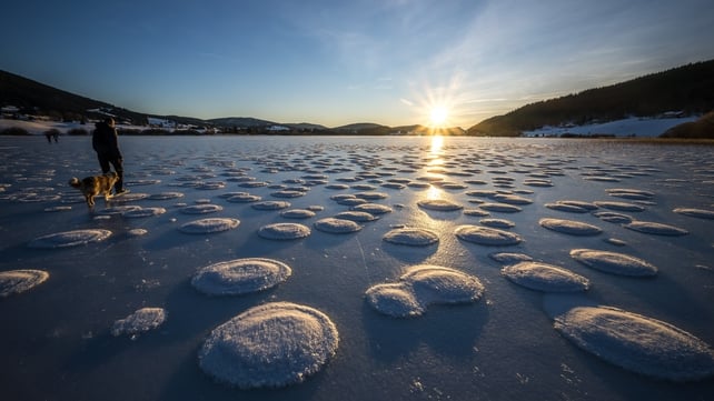 A person is seen strolling between pancakes of snow on the frozen Lade des Rousses in central-eastern France