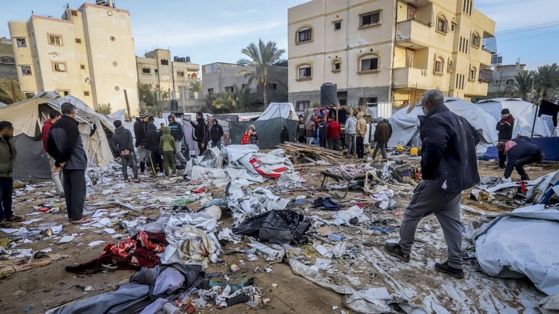 Palestinians inspect damaged tents for displaced people following an Israeli strike in Deir el-Balah, Gaza Strip