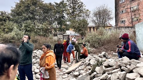 People gather in an open area following earthquake tremors in Kathmandu
