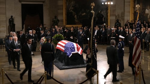 Guests pay their respects in front of the flag-draped casket at the Lying in State Ceremony for former President Jimmy Carter