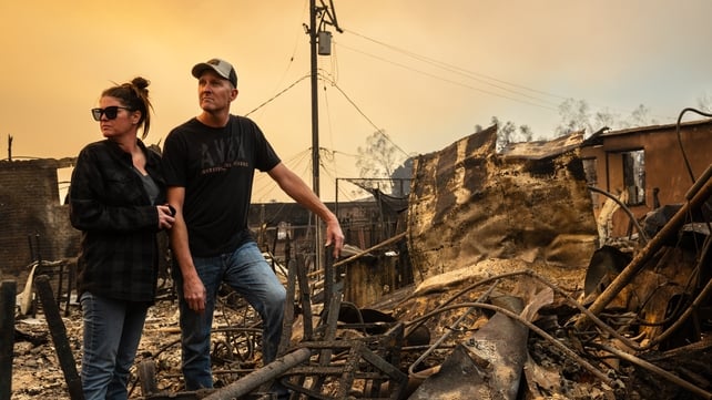 A couple surveys the ruins of their business, the Rancho Bar, destroyed by the Eaton Fire in Altadena, California - they also lost their nearby home in the fire