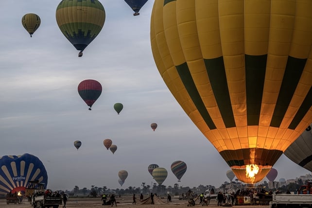 Tourists are helped into the basket of a hot air balloon before flying above the west bank of the Nile river in Egypt's southern city of Luxor