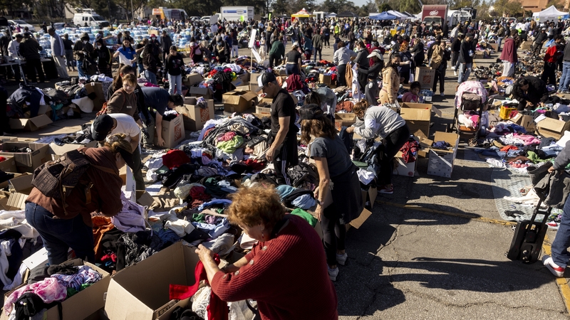 Evacuees from the Eaton Fire dwell among heaps of clothes displayed at a donation center in Santa Anita Park, Arcadia, California
