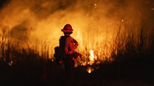 A firefighter monitors the spread of the Auto Fire in Oxnard, northwest of Los Angeles, California