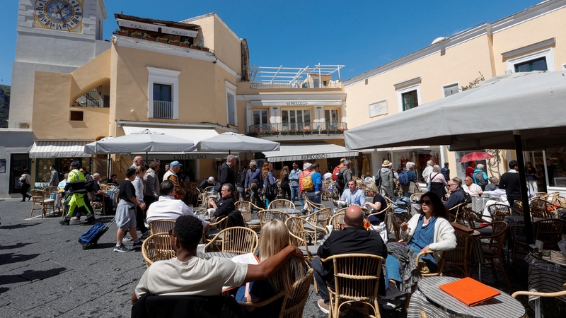 People sit outside restaurants and cafes on Capri Island, Italy