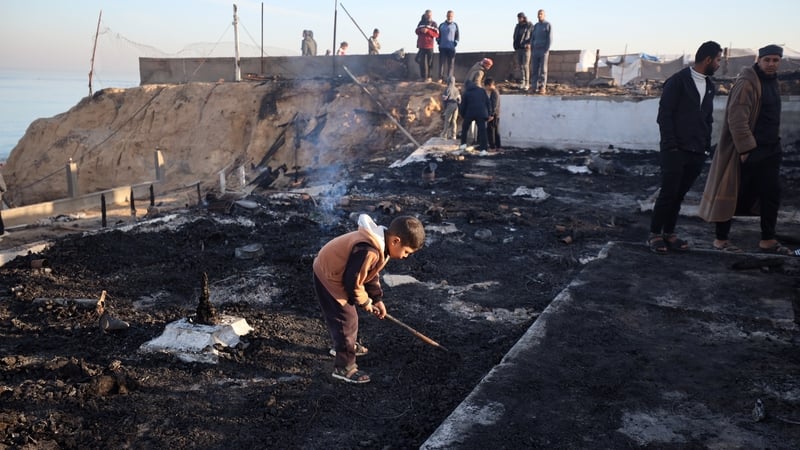 Palestinians inspect the site of an Israeli strike on a beachfront café in Deir Al-Balah