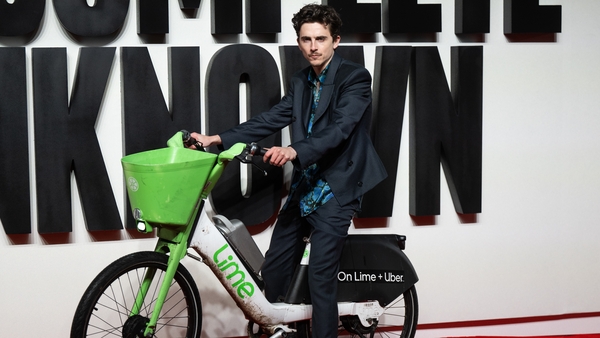 Timothee Chalamet arrives at A Complete Unknown premiere in London on a Lime bike