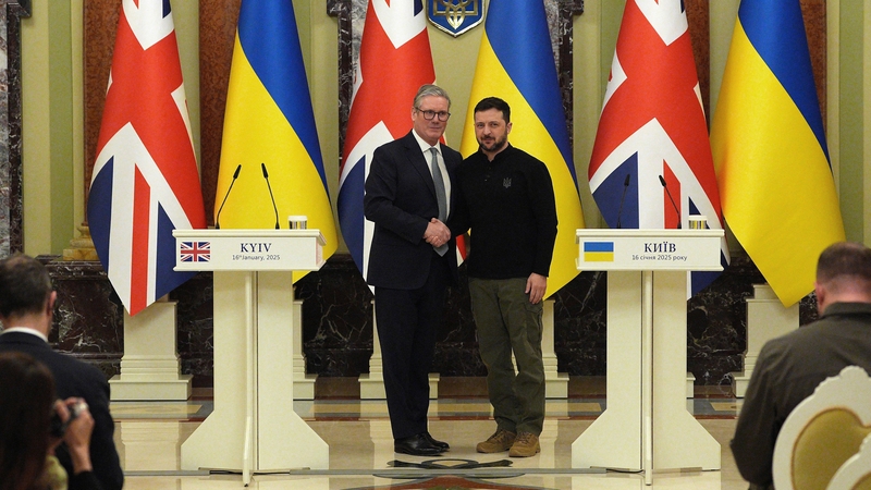 Britain's Prime Minister Keir Starmer and Ukrainian President Volodymyr Zelensky (R) shake hands during a joint press conference in Kyiv