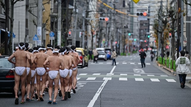 Shinto believers of Teppozu Inari Shrine run around the shrine to warm up before taking a bath in cold water to purify their souls and bodies during an annual New Year ritual in Tokyo