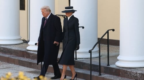 Melania Trump wore a long navy coat and matching wide-brimmed hat - which shielded her eyes in most photos