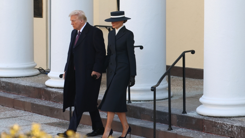 Melania Trump wore a long navy coat and matching wide-brimmed hat - which shielded her eyes in most photos