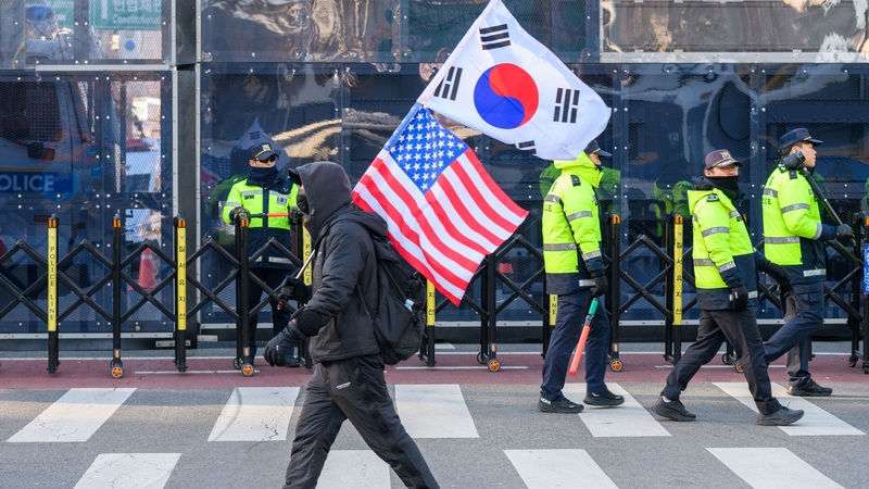 A supporter of the impeached South Korean president Yoon Suk Yeol walks past police officers blocking the way to the Seoul Constitutional Court