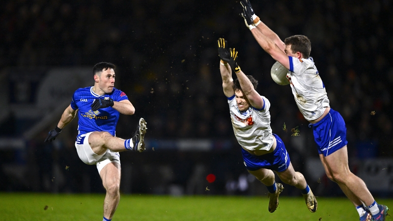 Ryan O'Neill of Cavan has his kick blocked by Monaghan pair Killian Lavelle (L) and Conor McCarthy