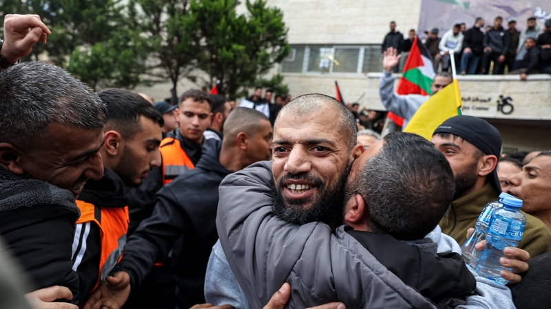 One of the Palestinian prisoners released by Israel embraces a man after disembarking a Red Cross bus in Ramallah