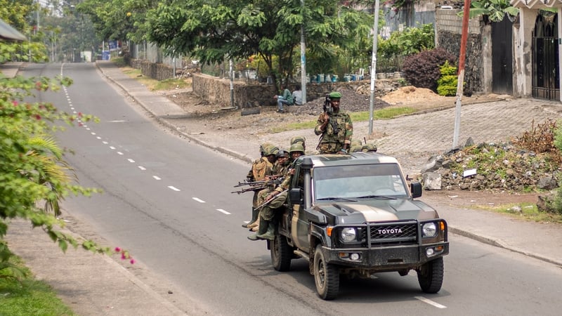 Armed men travel in a pickup truck, as they drive through a street in Goma