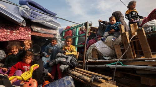 Displaced Palestinian children sit on the back of trucks waiting along Salah al-Din road in Nuseirat as people make their way to the northern part of Gaza