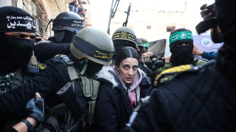 Sibhialtach Iosraelach á tabhairt ar láimh do Chumann na Croise Deirge ag Jiohád Ioslamach na Palaistíne