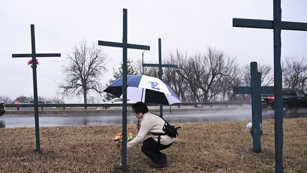 A woman places flowers at a makeshift memorial for the victims of the deadly mid-air collision near Reagan National Airport
